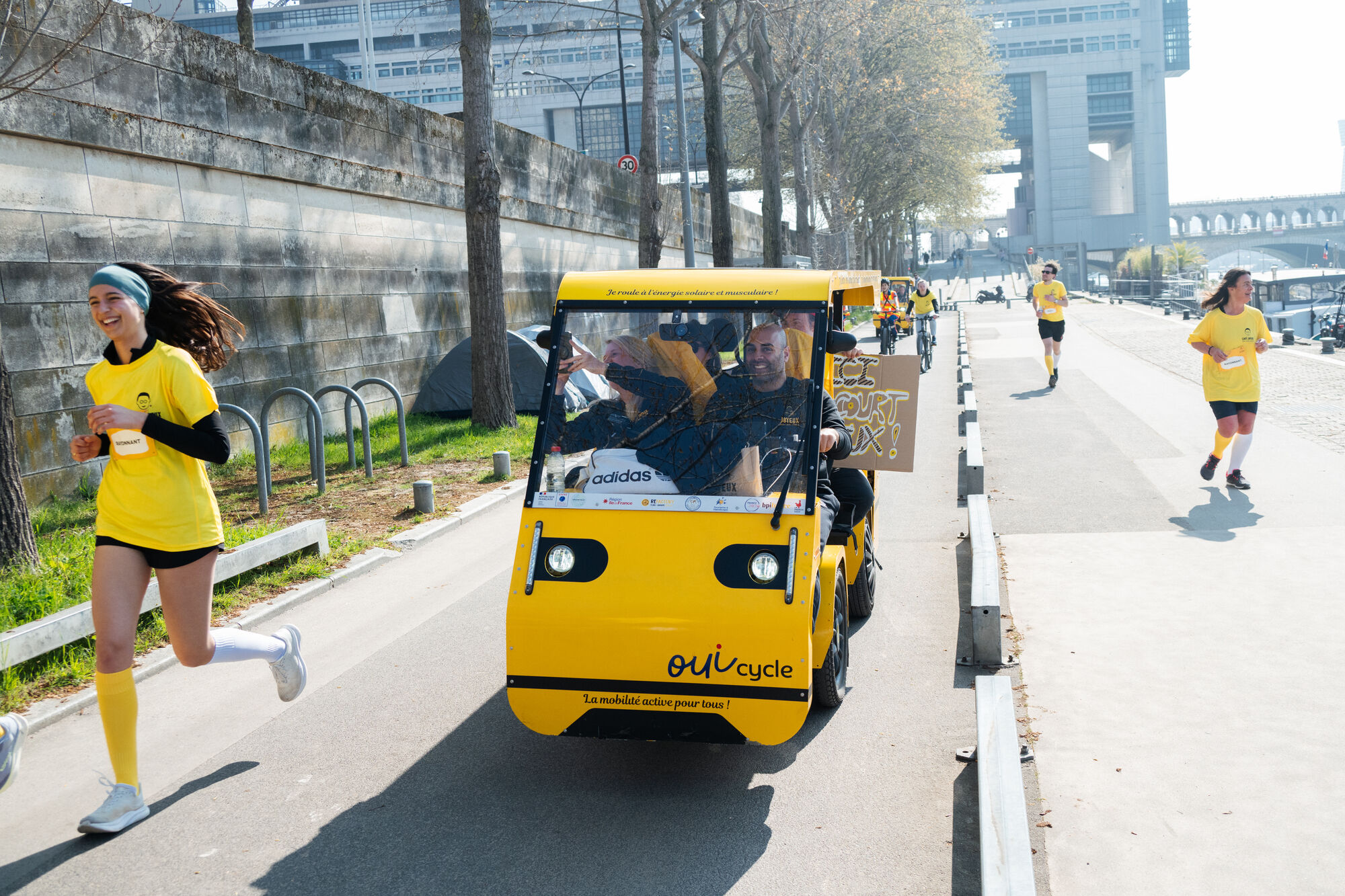 Le OuiCycle en sortie en extérieur : un groupe pédale ensemble, sourires.