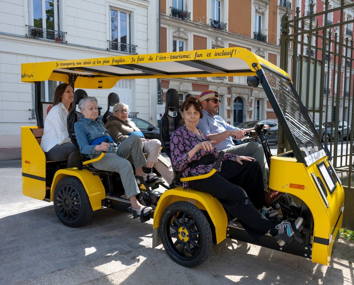 Le OuiCycle plein de passagers dans une rue : une accompagnante, des résidentes et le conducteur-animateur.