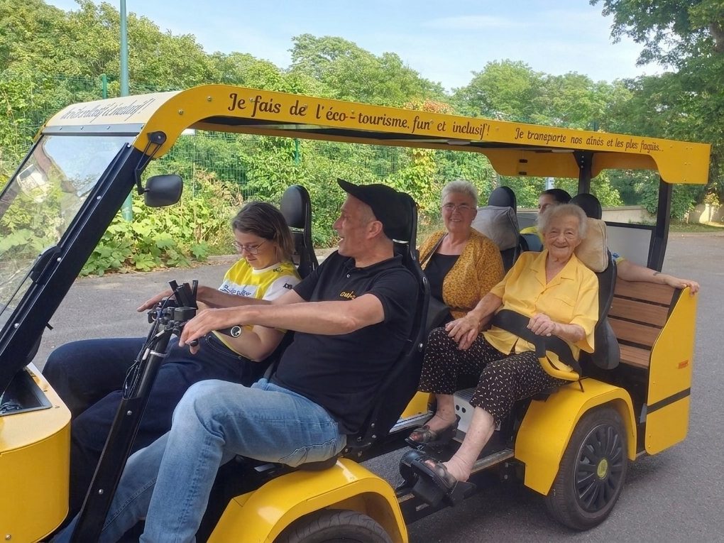 Quatre adultes installés à bord du OuiCycle pédalent ensemble dans un parc.