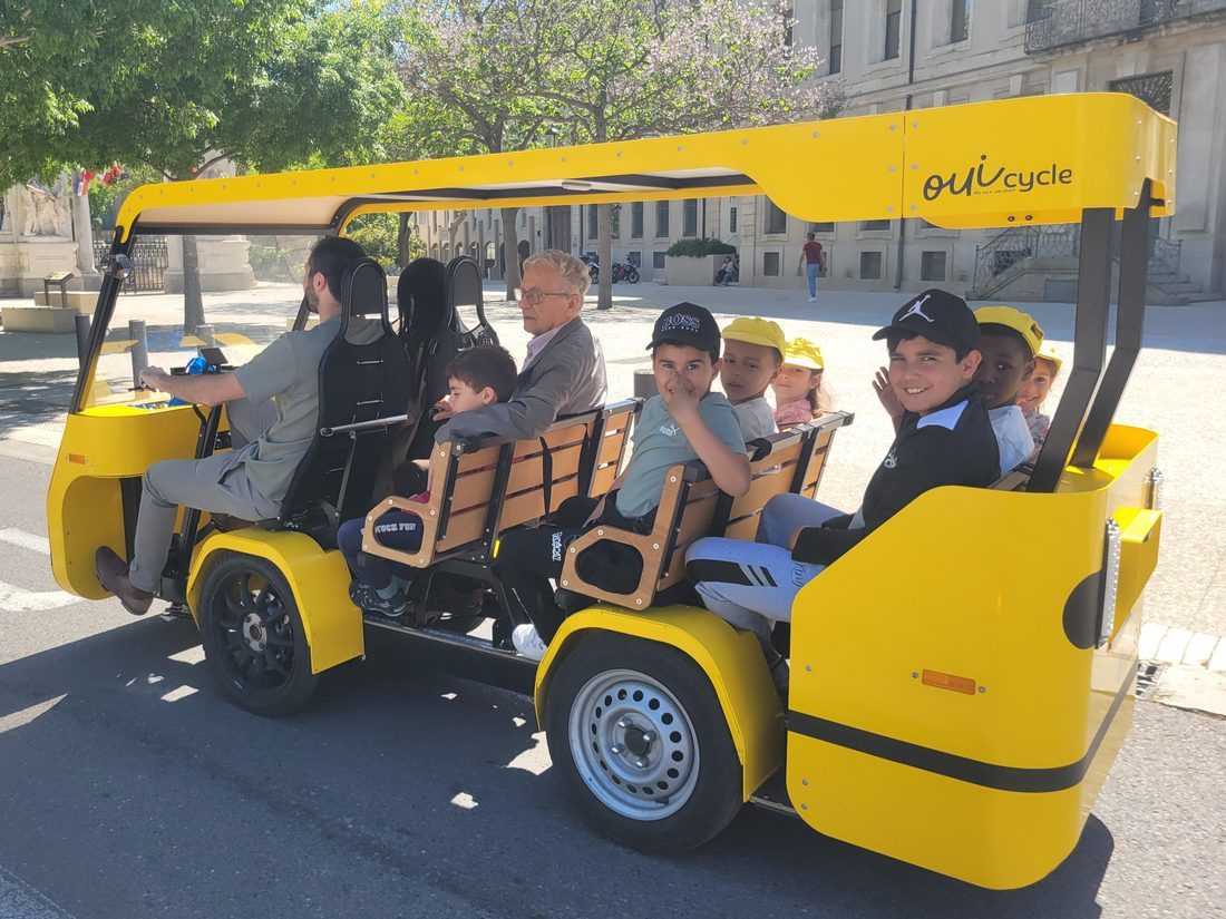 Le OuiCycle en configuration transport d’enfants : banquettes bois occupées par un groupe d’écoliers.