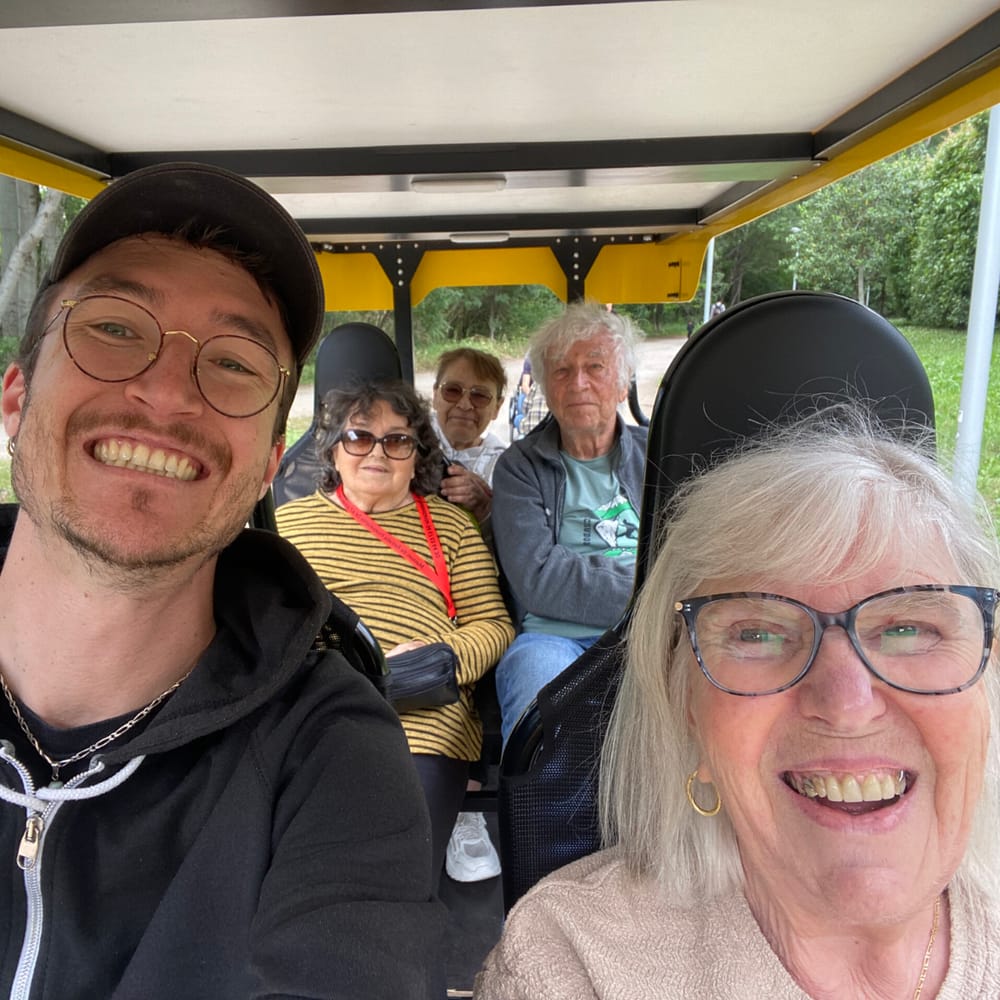 Une sortie de groupe souriante à bord du OuiCycle, accompagnante et résidents réunis.