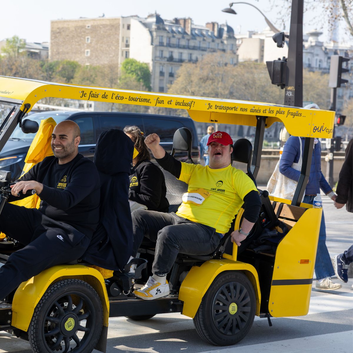 Sortie joyeuse à bord d'un vélo collectif jaune Les Roues Solidaires dans les rues de Paris, avec un passager souriant.